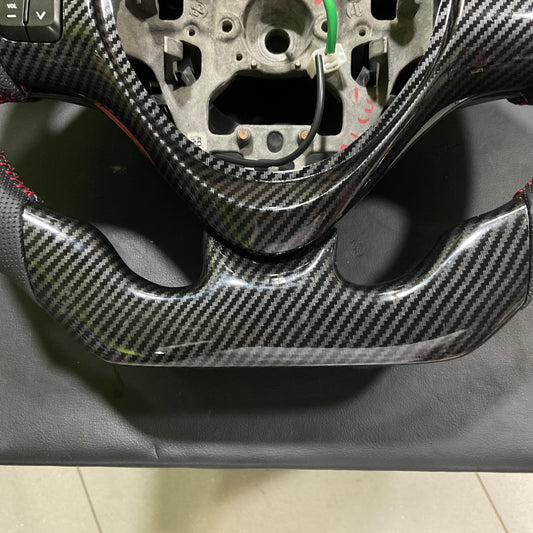 Carbon Fiber Multimedia Steering for Suzuki Alto 2014-2025 with integrated multimedia controls and a sleek, stylish finish.