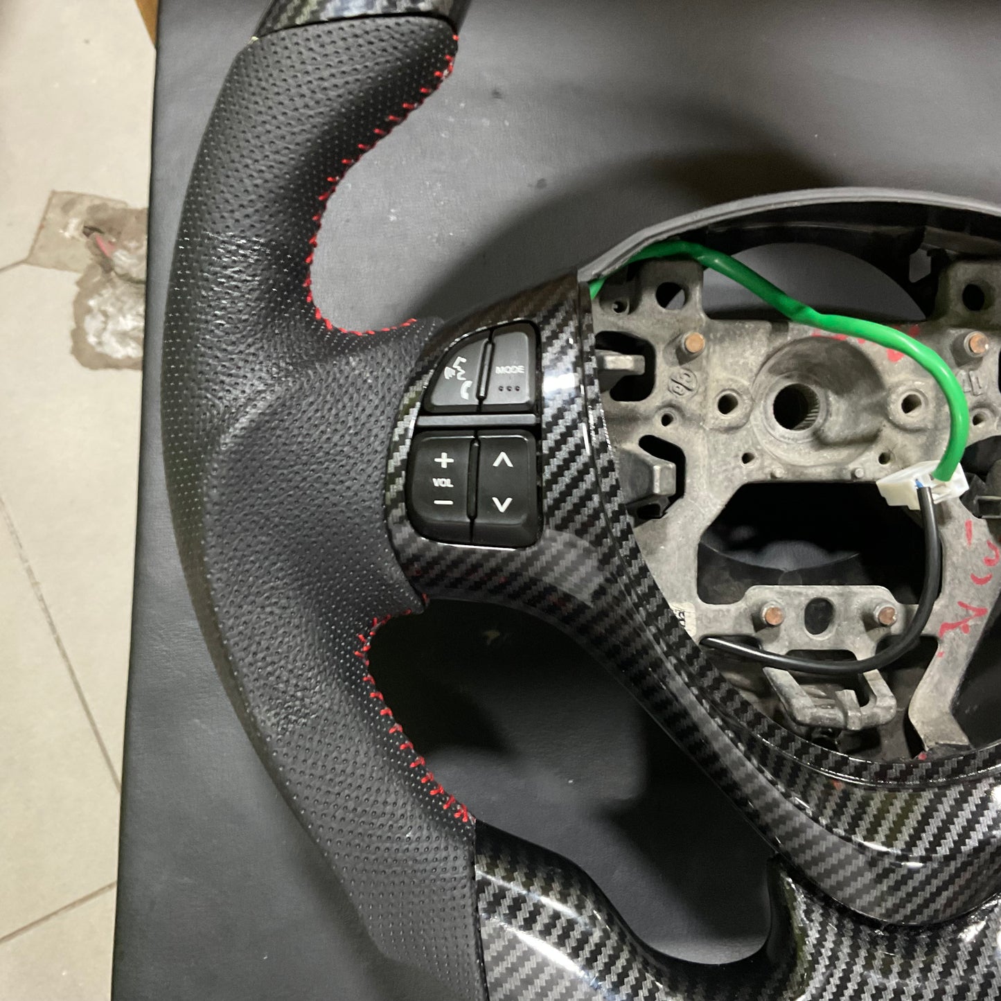 Carbon Fiber Multimedia Steering for Suzuki Alto 2014-2025 with integrated multimedia controls and a sleek, stylish finish.