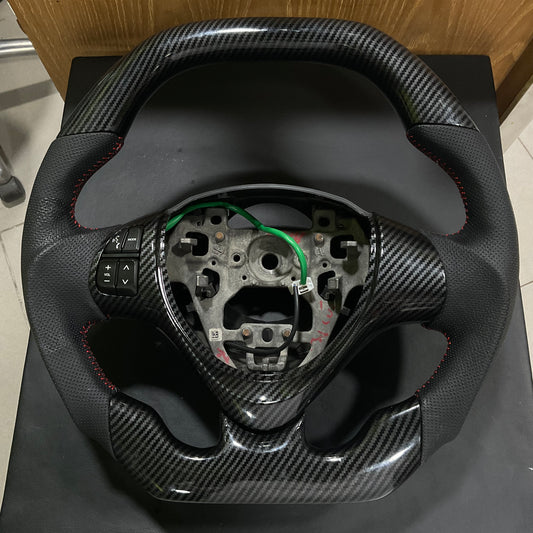 Carbon Fiber Multimedia Steering for Suzuki Alto 2014-2025 with integrated multimedia controls and a sleek, stylish finish.
