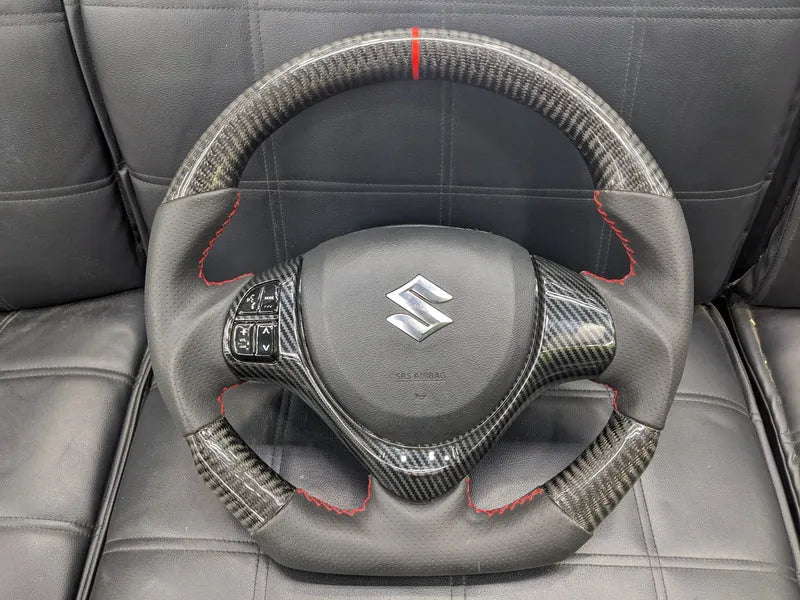 "Carbon Fiber Steering Wheel with Spiral for Suzuki Alto – Premium Grip, Sporty Look, and Durable Design."

